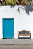 Teal Door and Bench against a Rustic Whitewashed Wall