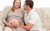Happy man touching the belly of his pregnant wife