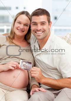 Proud couple of future parents holding an echography