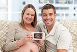 Joyful future parents looking at an echography together