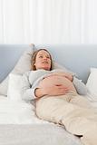 Pretty pregnant woman resting on a bed