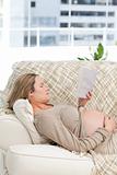 Portrait of a future mom reading a book lying