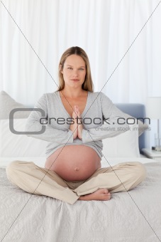 Serious pregnant woman doing yoga