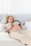 Cute future mom putting headphones on her belly
