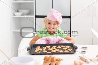 Happy little girl holding a plate with her cookies ready to eat