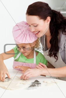 Happy mother and daughter cooking biscuits together