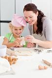Cheerful mother and daughter making cookies in form of a man 