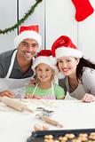 Cheerful family kneading biscuits for Christmas
