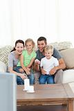 Happy family laughing while watching television sitting 