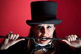 Woman in top hat biting whip