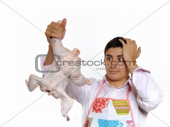 Handsome young man holding chicken preparing to cook