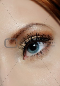 Beautiful macro shot of blue eye with long lashes and make-up