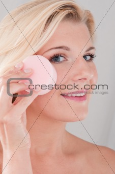 beautiful gir cleansing her face with sponge