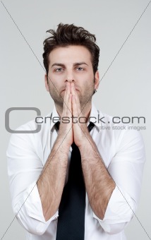 businessman in white shirt and tie holding hands together, praying - isolated on gray