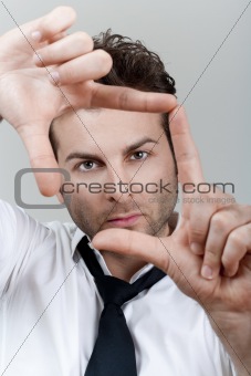 businessman in white shirt and tie forming frame with his fingers focusing