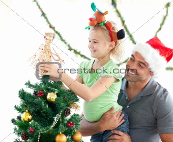 Cute little girl decorating the christmas tree with her father