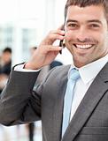 Cheerful businessman on the phone during a meeting with his team