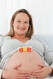 Adorable future mother with mom letters on her belly 