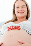 Close up of a woman having mom letters on her belly lying