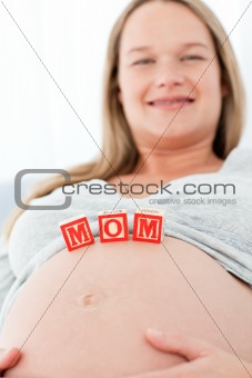Close up of a woman having mom letters on her belly lying