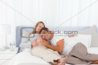 Funny man putting his head on the belly of his pregnant wife 