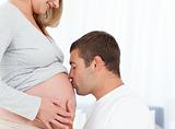 Lovely future dad kissing the belly of his wife