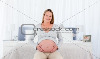 Joyfull pregnant woman in her bedroom