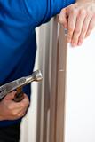 Close-up of a manual man building furniture using a hammer and a
