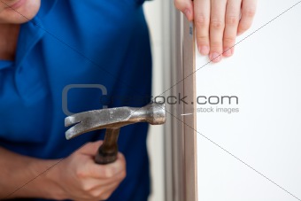 Close-up of a handyman building furniture using a hammer and a n