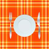 Dinner plate, knife and fork over orange tablecloth