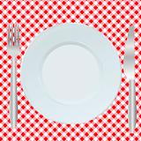 Plate, fork and spoon on red square tablecloth