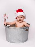 Baby in Basin Holding Candy Cane and Wearing Santa Hat