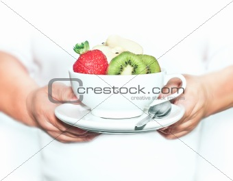 Person Holding a White Bowl of Fruit