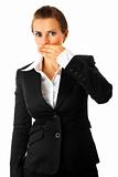 Surprised modern business woman closing mouth by hand 
