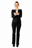 Full length portrait of smiling modern business woman presenting something on empty hands
