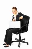 Smiling modern business woman  sitting on chair  and  pointing  finger on suitcase in her hand
