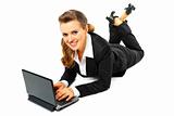 Laying on floor smiling modern business woman using  laptop
