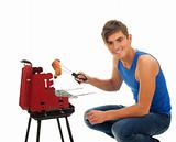 young man grilling chicken