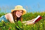 Young girl reading book in meadow