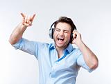 man in blue shirt with earphones listening to music - isolated on gray