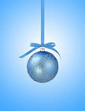 Blue christmas ball with ribbon on blue background with copy spa