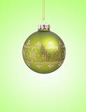 Green christmas ball with ribbon on green background with copy s
