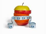 Slices of apples and orange as one fruit and a measuring tape