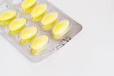 pack of yellow medicine pills on white background