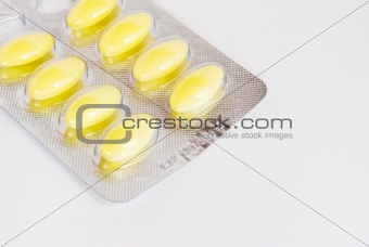 pack of yellow medicine pills on white background