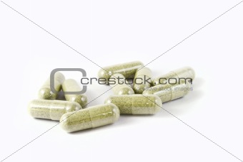 green herbal medicine capsule isolated on white background