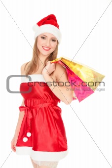 Pretty girl in a red Christmas hat with colorful bags