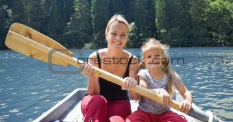 Woman and little girl on the lake in a little boat