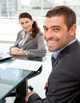 Cheerful business people sitting at a table with a laptop 