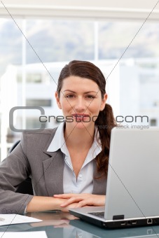 Smiling businesswoman on the computer looking at the camera